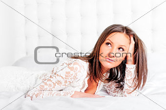 Portrait of a beautiful girl lying in bed.