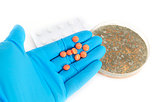 orange pills on arm in glove and fungi