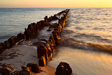 old breakwater in North sea at sunset