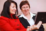 Two women sharing a tablet computer