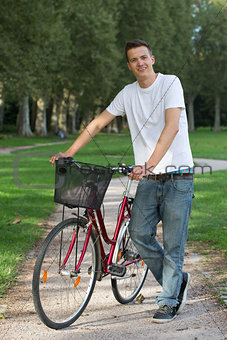 Young man standing next to his bike
