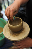Human hands creating clay pot on wheel
