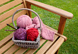 Basket of knitting and yarns on a bench