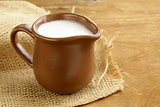 ceramic brown  jug full of milk, rustic style