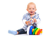 Cute little boy playing with pyramid toy over white background