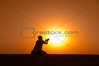 Man silhouette kneel and pray for help