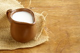 ceramic brown  jug full of milk, rustic style