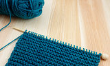 Garter stitch on knitting needle with teal yarn