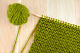 Green wool and garter stitch on knitting needle