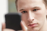 young man lokking in the screen of mobile phone
