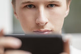 young man lokking in the screen of mobile phone