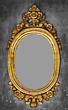 Old-fashioned gilt frame for a mirror on a concrete wall