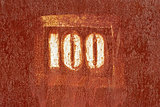 Number 100 painted on an old rusty surface