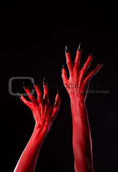 Spooky red demonic hands with black nails, real body-art 