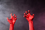 Spooky red devil hands with black glossy nails  