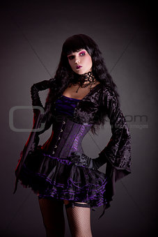 Romantic gothic girl in purple and black gothic Halloween outfit
