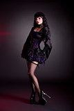 Pretty young woman in Victorian purple and black Halloween outfi