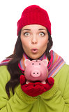 Expressive Mixed Race Woman Wearing Winter Hat Holding Piggybank