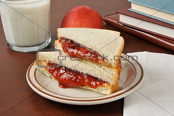 Peanut butter and jelly sandwich with school books