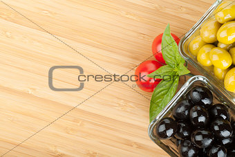 Olives, tomatoes and basil on cutting board