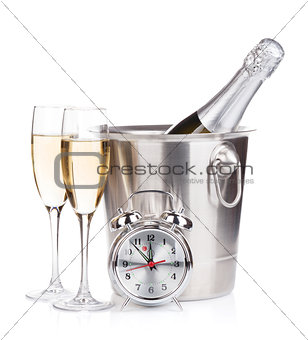 Champagne bottle in bucket, two glasses and alarm clock