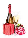 Champagne bottle, two glasses, gift box and red rose flowers
