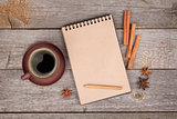 Blank notepad with coffee cup and spices on wooden table