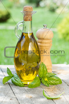 Olive oil bottle, pepper shaker and basil
