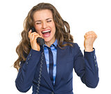 Happy business woman talking phone and rejoicing
