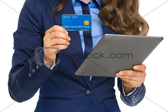 Closeup on business woman with credit card using tablet pc