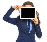 Business woman holding tablet pc with blank screen in front of f