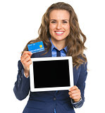 Smiling business woman holding tablet pc blank screen and credit