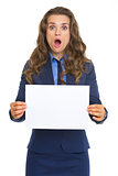 Surprised business woman showing blank paper sheet