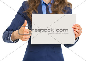 Closeup on business woman showing blank paper sheet and thumbs u