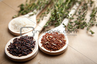 Red and white rice on wooden spoons