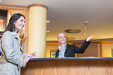 Smiling receptionist helping a hotel guest