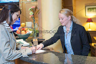 Receptionist helping a hotel guest check in
