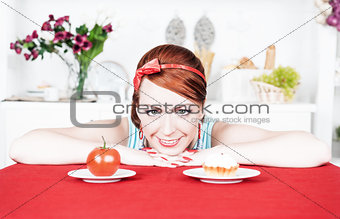 Smiling woman choosing between tomato and cake