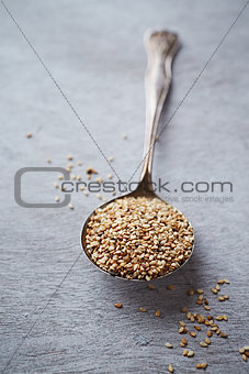 Organic sesame seeds on a spoon (unhulled)