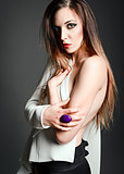 Studio fashion shot: a sexy beautiful girl in white jacket against gray background
