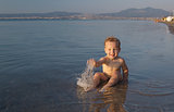 Cute little boy splashing in the sea