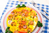 Omelette with slices of sausage and tomato