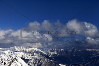 Winter sunlit mountains and sky with clouds