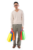 Bored Asian man holding shopping bags