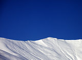 Off-piste slope and blue clear sky in nice winter day