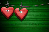 Red Wooden Hearts on Green Wood Background