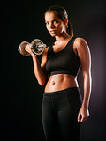 Serious woman lifting a dumbbell