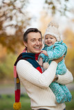 Portrait of young father and his little son in autumn park