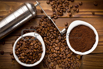 coffee beans with ground coffee and grinder