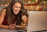 Smiling young woman showing christmas cookies while having video